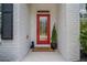 A bright red front door with glass panel, framed by white brick and complemented by a 'welcome' mat at 1059 Rockford Township Sw Dr, Marietta, GA 30064