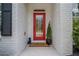 A red front door with glass insert is framed by white painted brick, potted plants, and black shutters at 1059 Rockford Township Sw Dr, Marietta, GA 30064