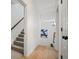 Hallway with wood floors, carpeted stairs, white walls, and modern lighting fixtures at 1059 Rockford Township Sw Dr, Marietta, GA 30064