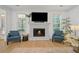 Cozy living room featuring a stone fireplace, hardwood floors, natural light, and comfortable blue chairs at 1059 Rockford Township Sw Dr, Marietta, GA 30064