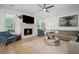 Bright living room featuring a stone fireplace, hardwood floors, a ceiling fan, and a cozy sectional sofa at 1059 Rockford Township Sw Dr, Marietta, GA 30064