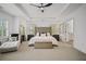 This primary bedroom has a trey ceiling, a seating area, and neutral carpet at 1059 Rockford Township Sw Dr, Marietta, GA 30064