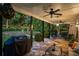 Covered patio with stone floor, ceiling fan, grill, and view of the landscaped backyard at 1059 Rockford Township Sw Dr, Marietta, GA 30064