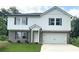 Two story home featuring a brick and white plank exterior, attached two car garage, and newly installed lawn at 107 Deer Xing, Temple, GA 30179