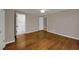 A gray bedroom with hardwood floors, closet, and a doorway to a utility area at 4102 Barr Cir, Tucker, GA 30084