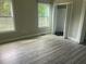 Bright bedroom with wood-look flooring, complemented by natural light streaming through the window at 841 N North Price Rd, Sugar Hill, GA 30518