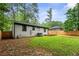 View of a house's white painted brick exterior with a vibrant green lawn and a modern wooden deck at 1719 San Gabriel Ave, Decatur, GA 30032
