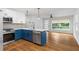 Bright kitchen features white and blue cabinets, stainless steel appliances, quartz countertops and hardwood floors at 1719 San Gabriel Ave, Decatur, GA 30032