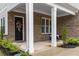 Charming front porch with brick accents, white columns, and decorative wreath on the front door at 4960 Iris St, Cumming, GA 30040