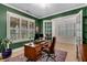 Stylish home office with green walls, natural light, hardwood floors, and French doors at 4960 Iris St, Cumming, GA 30040