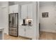 Kitchen coffee bar and stainless steel refrigerator are featured in this well-lit auxiliary space with hardwood floors at 4960 Iris St, Cumming, GA 30040