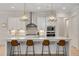 Modern kitchen boasts white cabinets, stainless steel appliances, a large island, and stylish pendant lighting at 4960 Iris St, Cumming, GA 30040