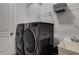Laundry room featuring modern washer and dryer, white cabinets, and a utility sink for added convenience at 4960 Iris St, Cumming, GA 30040