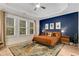 Bedroom features a tray ceiling, three windows with wooded backyard views, and blue accent wall at 4960 Iris St, Cumming, GA 30040