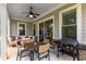 Relaxing covered patio features a ceiling fan, dining table, and outdoor seating with a grill at 4960 Iris St, Cumming, GA 30040