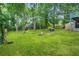 Large backyard with lush green grass, patio, and fire pit with mature trees at 4981 Crowe Se Dr, Smyrna, GA 30082