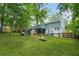 Backyard view of two-story home with lush green grass, patio, and fire pit at 4981 Crowe Se Dr, Smyrna, GA 30082