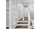 Stylish staircase featuring hardwood steps, white risers, built-in shelving, and a modern light fixture at 4981 Crowe Se Dr, Smyrna, GA 30082