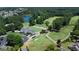 Aerial view of a lush golf course, clubhouse, and scenic pond surrounded by trees at 6765 Creek View Ln, Cumming, GA 30041