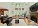 Bright living room featuring a stone fireplace, and many windows offering a view of the outdoors at 6765 Creek View Ln, Cumming, GA 30041