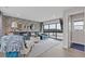 Inviting living room with an L-shaped sofa, mirrors, and a large sliding door to a balcony overlooking green trees at 830 Stone Ridge Ln, Atlanta, GA 30324