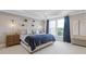 Elegant main bedroom featuring a plush bed with decorative pillows, sconces, and bright windows with blue curtains at 830 Stone Ridge Ln, Atlanta, GA 30324