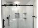 Modern bathroom boasts sleek glass enclosure with black hardware and elegant white tiled walls at 1101 Juniper Ne St # 922, Atlanta, GA 30309