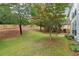 Lush backyard with a patio area, mature trees, and a wooden fence for privacy at 112 Rotherhithe Nw Ln, Marietta, GA 30066