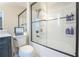 Bathroom featuring an updated bathtub, a glass door, and tiled walls at 3497 Mount Vernon Cir, Atlanta, GA 30340