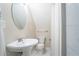 Compact bathroom featuring a pedestal sink and toilet under a cozy, sloped ceiling, maximizing space at 3497 Mount Vernon Cir, Atlanta, GA 30340