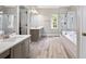 Open bathroom featuring double vanity, white tiled jacuzzi tub, and glass shower enclosure at 992 Marbury Sw Ct, Marietta, GA 30064