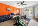 Colorful bedroom featuring bright orange walls, two beds, and comfortable gaming chairs at 992 Marbury Sw Ct, Marietta, GA 30064