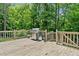 Spacious wooden deck featuring a grill and surrounded by lush greenery, perfect for outdoor entertaining at 992 Marbury Sw Ct, Marietta, GA 30064