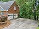 Long driveway leading to a two-car garage with mature trees and a basketball hoop in the background at 992 Marbury Sw Ct, Marietta, GA 30064