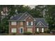 Charming brick home featuring a manicured lawn, blue front door, and classic architectural details at 992 Marbury Sw Ct, Marietta, GA 30064