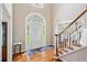 Bright foyer with hardwood floors, white staircase, and arched window above front door at 992 Marbury Sw Ct, Marietta, GA 30064