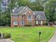 Well-maintained lawn and landscaping frame this two-story brick home with a blue front door and dark shutters at 992 Marbury Sw Ct, Marietta, GA 30064