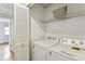 Bright laundry room with white washer, dryer, shelving, and access to hall, for easy and convenient laundry at 1002 Defoors Nw Lndg, Atlanta, GA 30318