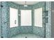 Modern shower featuring blue mosaic tile and clear glass doors for a spa-like experience at 1002 Defoors Nw Lndg, Atlanta, GA 30318