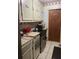 Compact kitchen featuring neutral cabinetry and modern stainless steel appliances, adjoining a laundry room at 36 Wolf Pen Path, Dallas, GA 30157