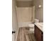 Bathroom with tub-shower combination featuring laminate floors and granite vanity at 948 Regency Dr, Lawrenceville, GA 30044