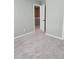 Neutral toned bedroom with plush carpeting and a bright white door frame leading to the hall at 948 Regency Dr, Lawrenceville, GA 30044