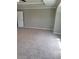 Spacious bedroom featuring plush carpeting, neutral paint, and a door at 948 Regency Dr, Lawrenceville, GA 30044