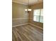 Dining room with modern chandelier, large window with blinds, and wood-style laminate flooring at 948 Regency Dr, Lawrenceville, GA 30044