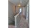 Bright upstairs hallway featuring neutral walls and carpeting, a staircase, and multiple doors at 948 Regency Dr, Lawrenceville, GA 30044