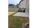 Backyard view of concrete patio, green and dry grass, and siding at 948 Regency Dr, Lawrenceville, GA 30044