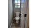 Bathroom featuring a standard toilet, window and laminate wood flooring at 948 Regency Dr, Lawrenceville, GA 30044