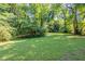 This is a backyard with a lush green lawn, mature trees, and plenty of space to relax or entertain at 4230 Cheryl Ann Ct, Stone Mountain, GA 30083