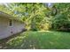 View of home's backyard, which has a lawn and mature trees, plus the house's exterior at 4230 Cheryl Ann Ct, Stone Mountain, GA 30083