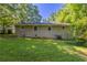 View of home's backyard featuring a lawn, mature trees, and the exterior of the house at 4230 Cheryl Ann Ct, Stone Mountain, GA 30083